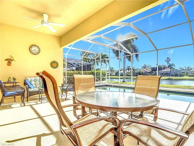 Sunroom / solarium with ceiling fan, a pool, and a water view