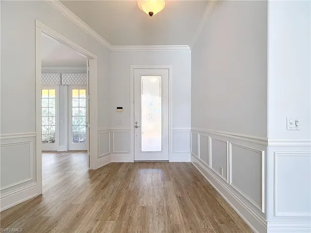 Entryway featuring crown molding and light hardwood / wood-style flooring