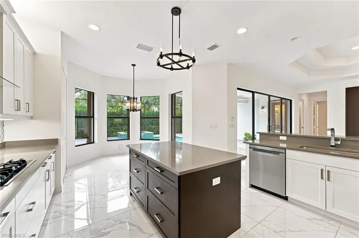 Open gourmet kitchen with stainless steel appliances and vented hood to outside, casual dining area, large center island.