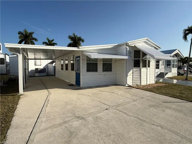 View of front facade featuring driveway and a carport