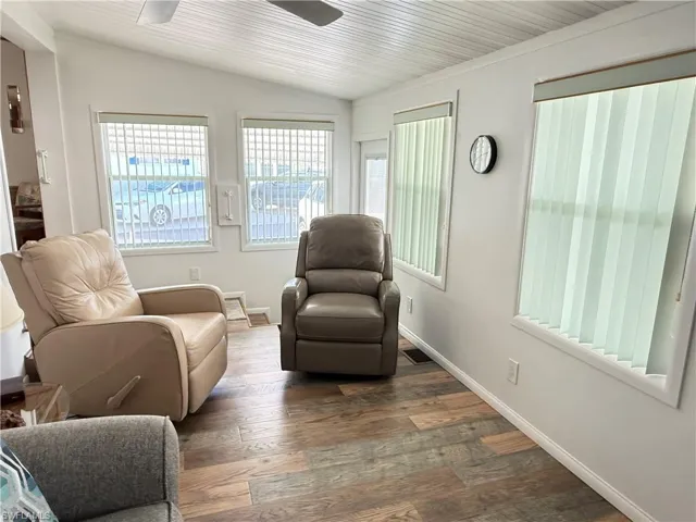 Sitting room featuring lofted ceiling, hardwood / wood-style floors, and ceiling fan