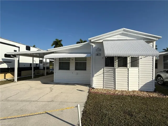 View of front of home with driveway and a carport