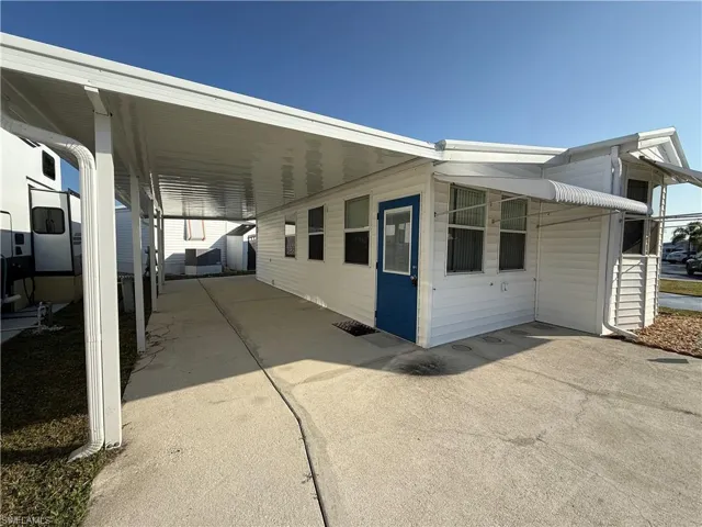 View of property exterior featuring a carport, concrete driveway, and a patio