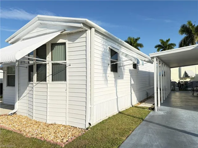 View of side of property featuring a carport and driveway