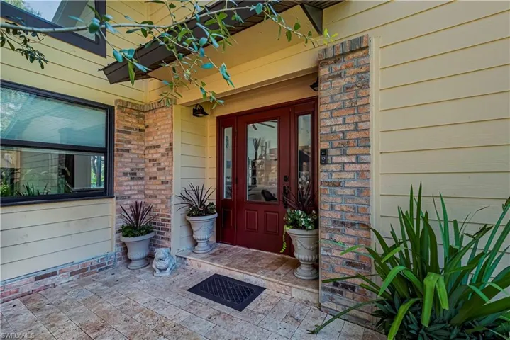 Entrance to property featuring brick siding