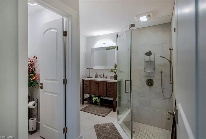 Bathroom with vanity, a stall shower, and tile patterned flooring
