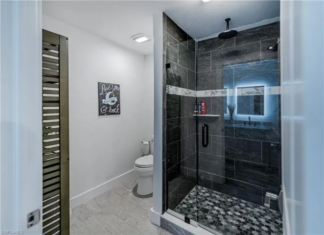 Full bathroom with a stall shower and toilet