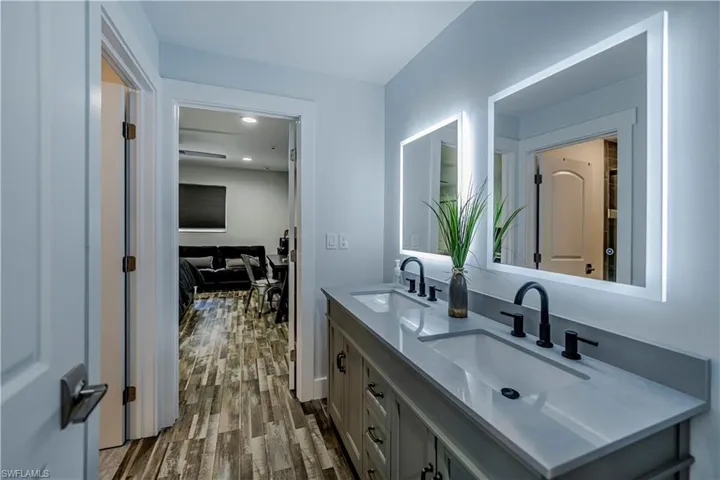 Bathroom featuring double vanity and wood finished floors