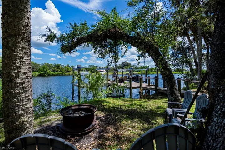 Dock area featuring a fire pit, a water view, and boat lift
