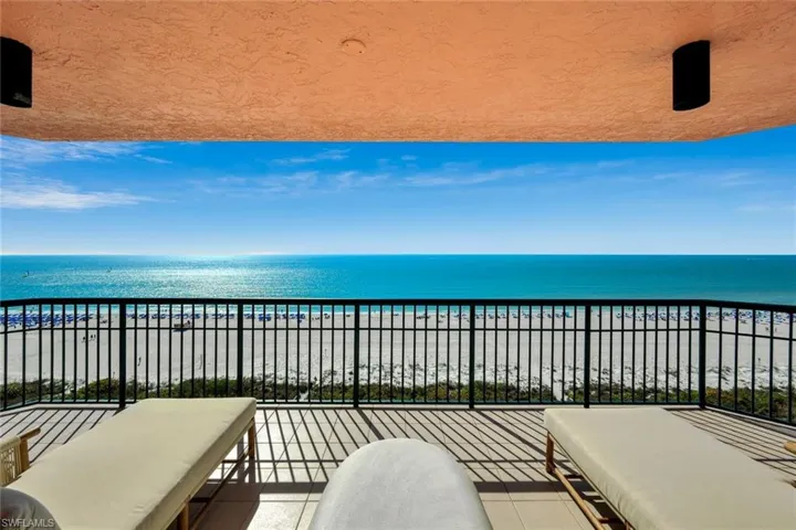 Large balcony with view of water and beach and outdoor lounge area