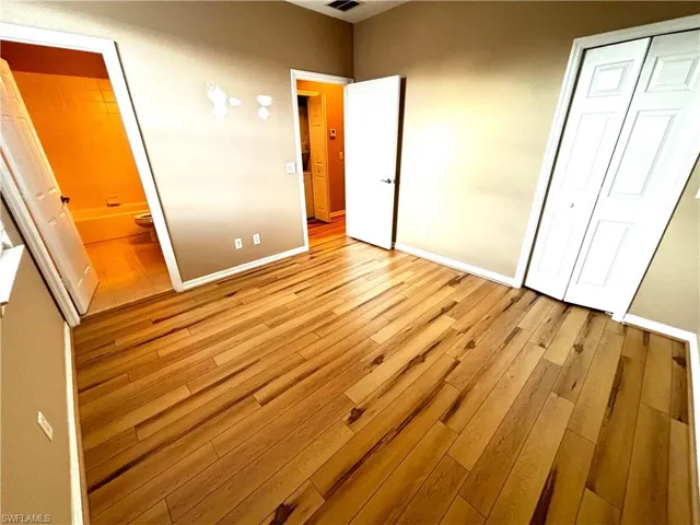 Unfurnished bedroom with light wood-style flooring, a closet, and ensuite bathroom