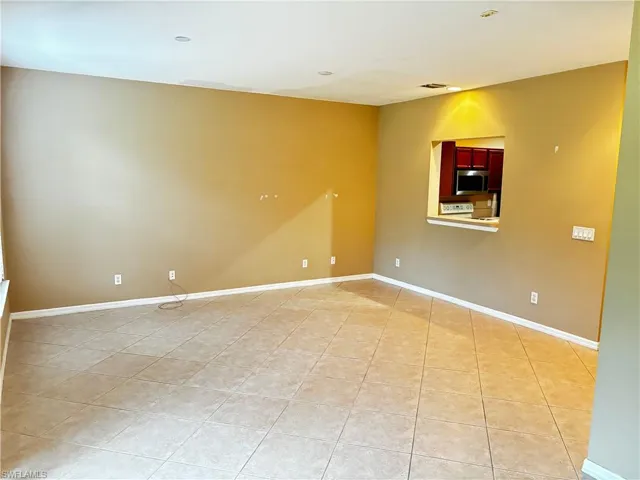 Empty room featuring baseboards and light tile patterned floors