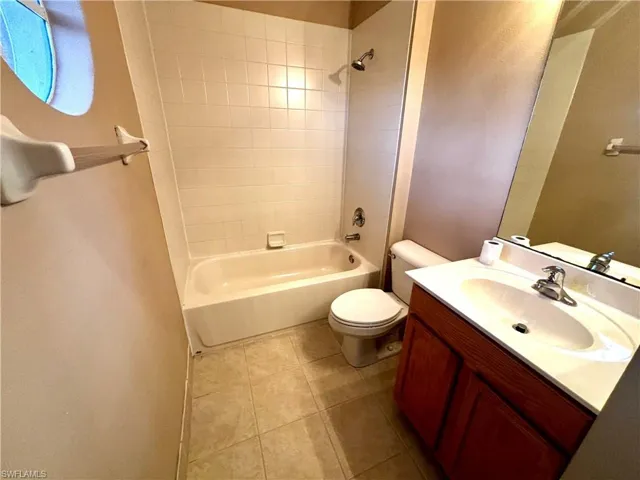 Bathroom with vanity, shower / tub combination, and light tile patterned floors
