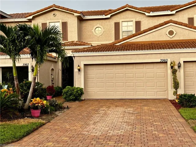 Mediterranean / spanish home featuring a tile roof, stucco siding, and decorative driveway