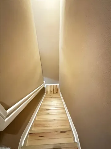 Stairs with wood-type flooring and baseboards