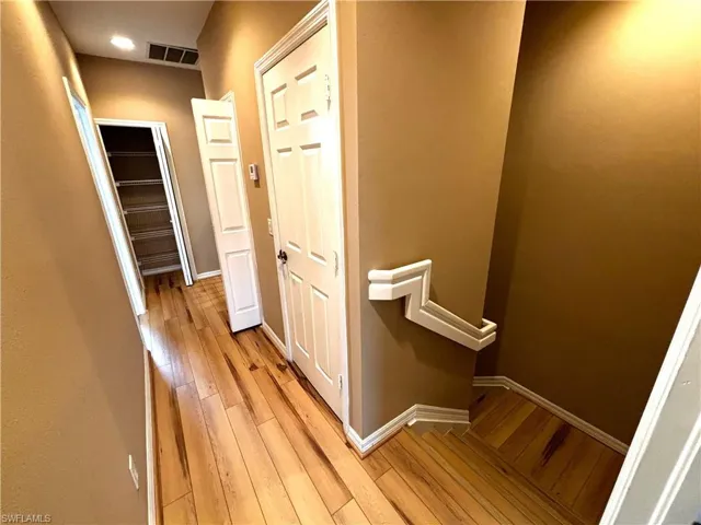 Hall featuring light wood-style floors and an upstairs landing