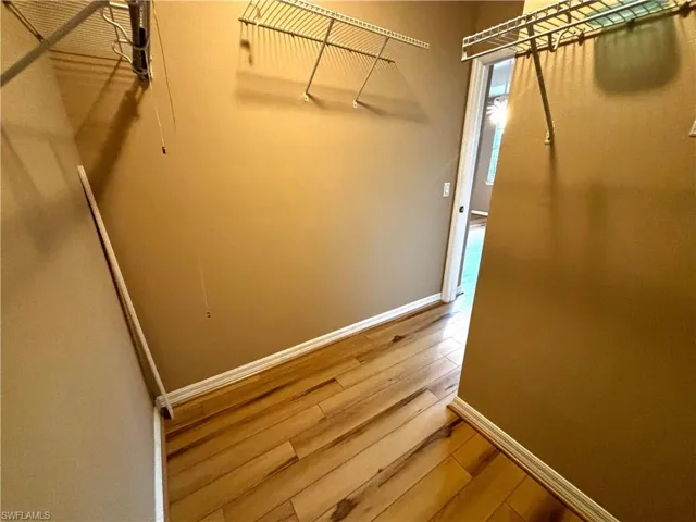 Walk in closet with light wood-type flooring