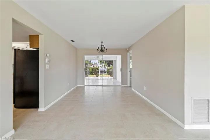Spare room with a chandelier and light tile patterned flooring