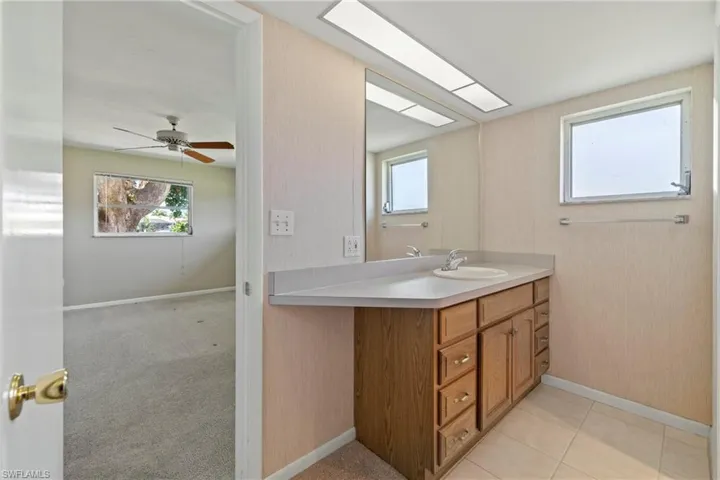 Bathroom featuring ceiling fan, vanity, and tile patterned floors
