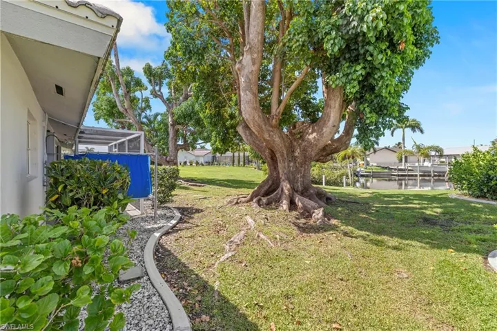View of yard featuring a water view and glass enclosure