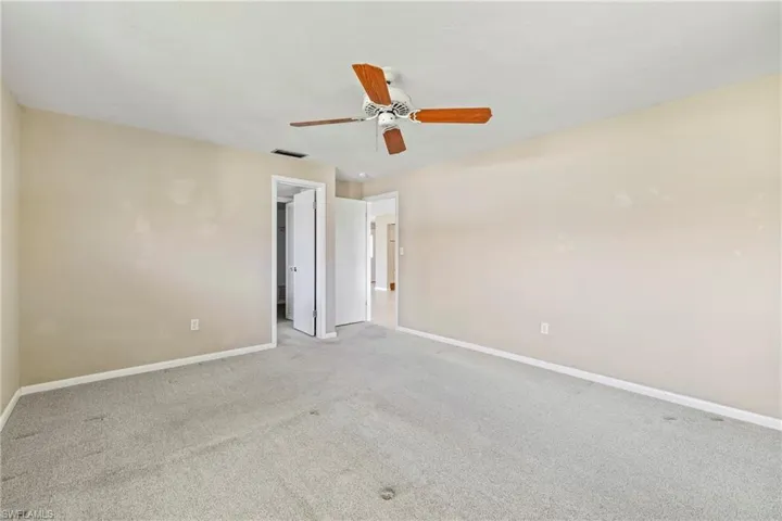 Carpeted empty room featuring ceiling fan