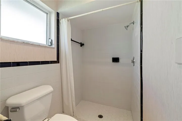 Bathroom with toilet and a shower with curtain