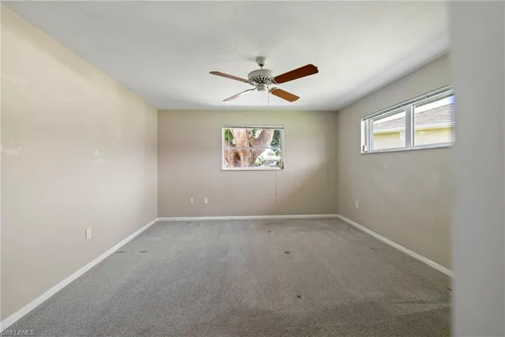 Empty room with ceiling fan and carpet floors