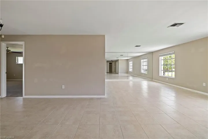 Empty room featuring light tile patterned flooring and ceiling fan