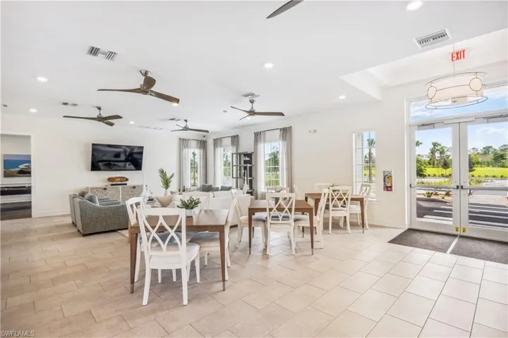 Spacious common area featuring light-toned tile flooring, recessed lighting, and multiple ceiling fans
