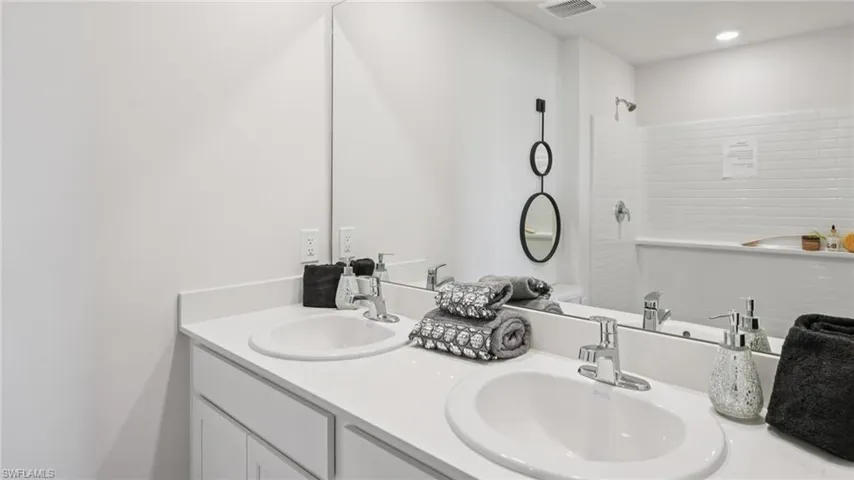 Modern bathroom featuring a dual vanity with undermount sinks and chrome fixtures