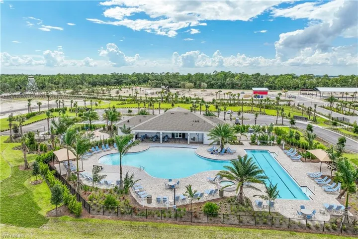Expansive community pool area featuring a freeform main pool, a rectangular lap pool, and integrated hot tubs