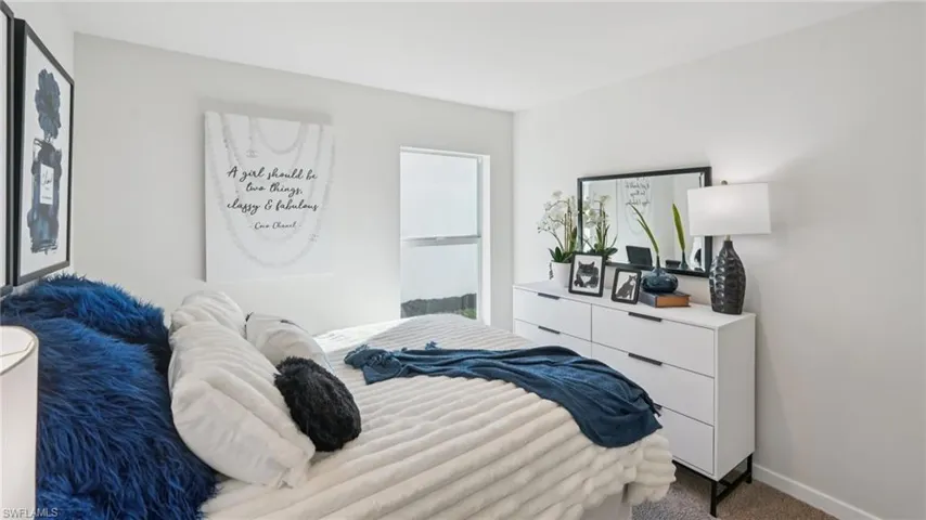 Bright room featuring light-toned walls and carpet flooring