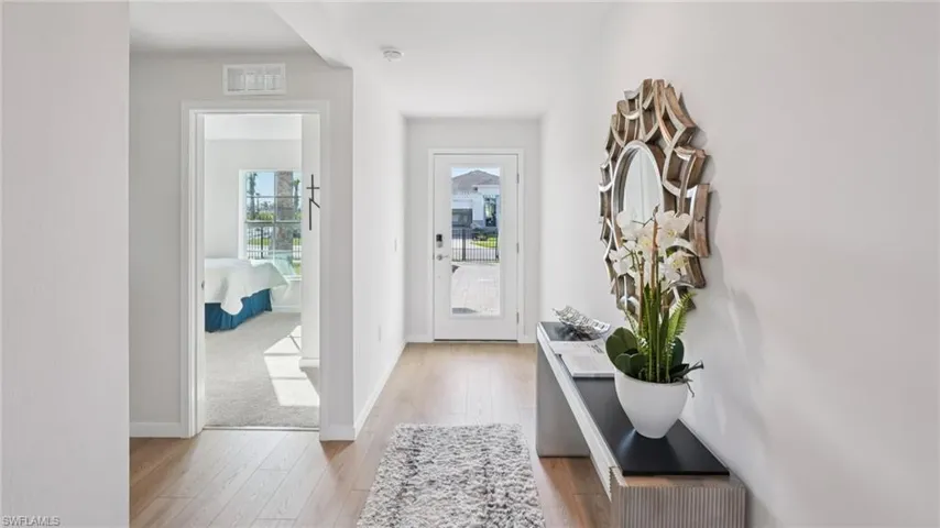 Bright entry hallway featuring wood-finish flooring and a glass-paneled entry door