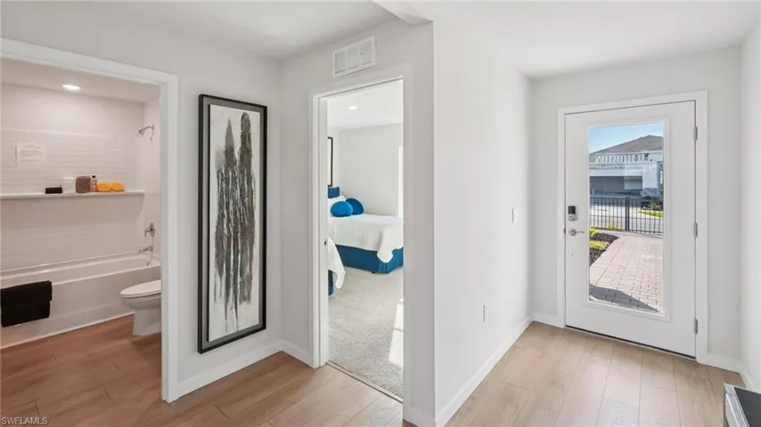 Bright entry hallway featuring wood-finish flooring and a glass-paneled entry door