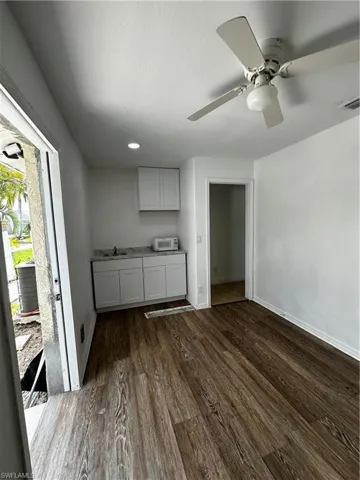 Kitchen with baseboards, dark wood-type flooring, a sink, and recessed lighting