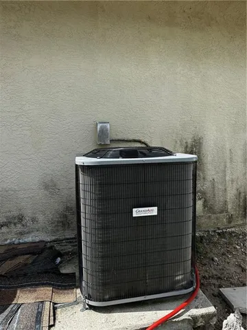 Exterior view of central air condition unit and stucco siding