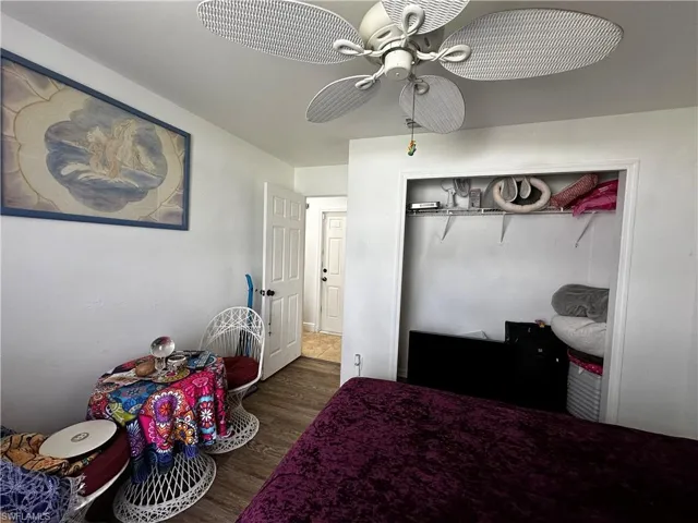 Bedroom with wood finished floors, ceiling fan, and a closet
