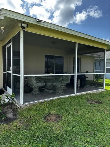 Back of house featuring a sunroom and a yard