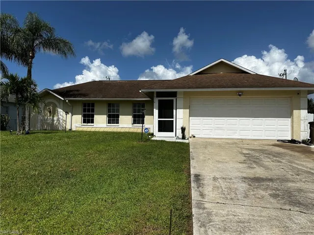 Ranch-style house featuring stucco siding, concrete driveway, a front yard, and an attached garage