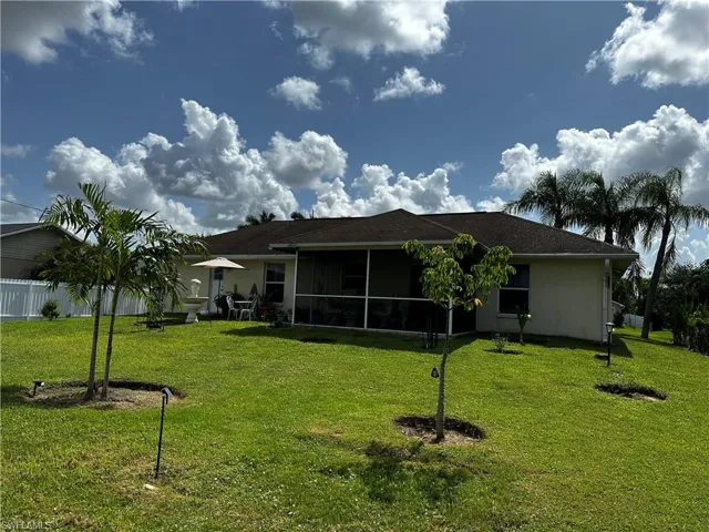 Rear view of house with a sunroom and stucco siding