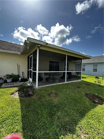 Back of property featuring a sunroom and stucco siding