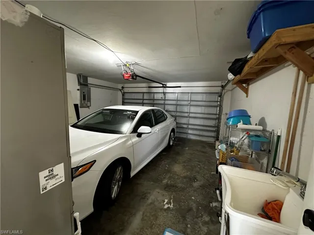 Garage featuring electric panel and a garage door opener