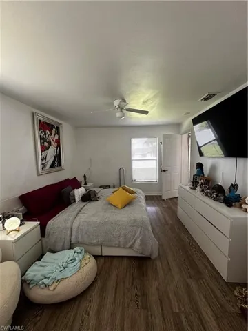 Bedroom with dark wood-style flooring and a ceiling fan