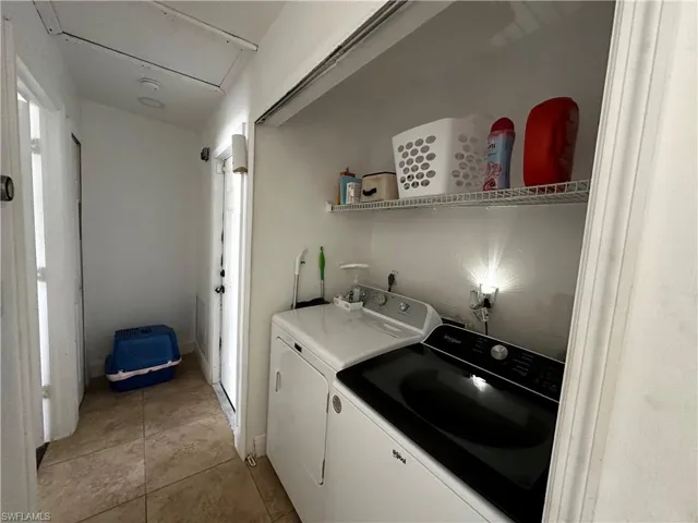 Laundry area featuring separate washer and dryer and light tile patterned floors