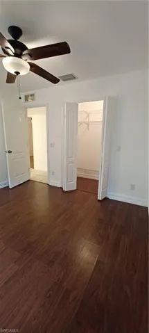 Spacious room Master Closet featuring wood-finish flooring, a ceiling fan with integrated lighting, white baseboards, and a bi-fold closet with shelving