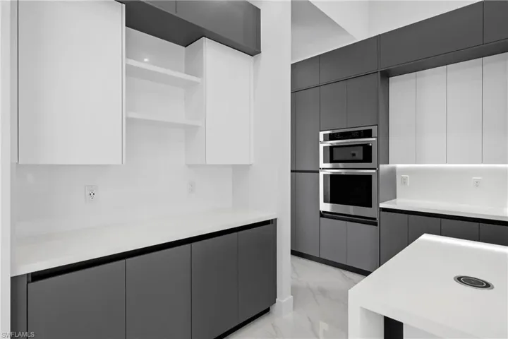 Kitchen with light marble finish flooring, open shelves, modern cabinets, and light countertops