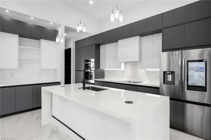 Kitchen featuring appliances with stainless steel finishes, open shelves, light marble finish floors, modern cabinets, and recessed lighting