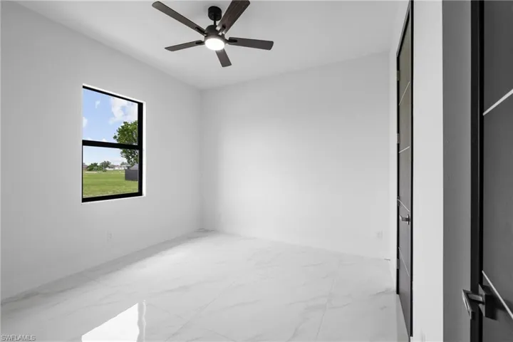 Unfurnished bedroom with marble finish flooring and a ceiling fan