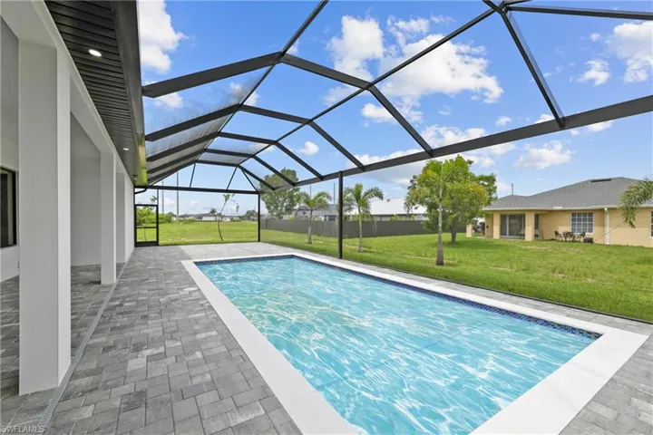 Outdoor pool featuring a lawn, a patio, and a lanai
