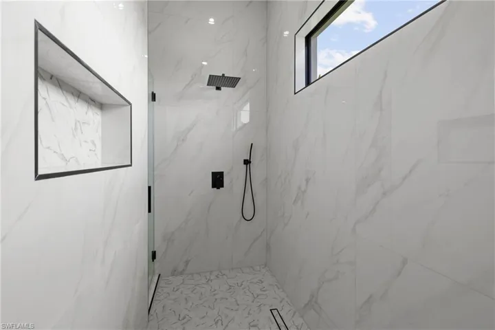 Bathroom featuring a marble finish shower